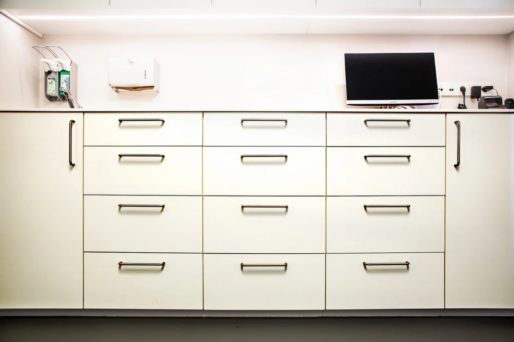 Fronten einer Laborküche in HPL weiß mit aufgeschraubten Griffen in Edelstahl.